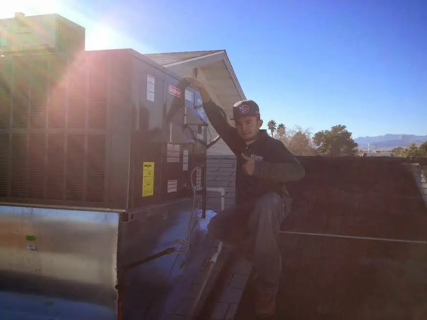 HVAC technician performing AC Tune-Up on a rooftop unit in Lake Barrington